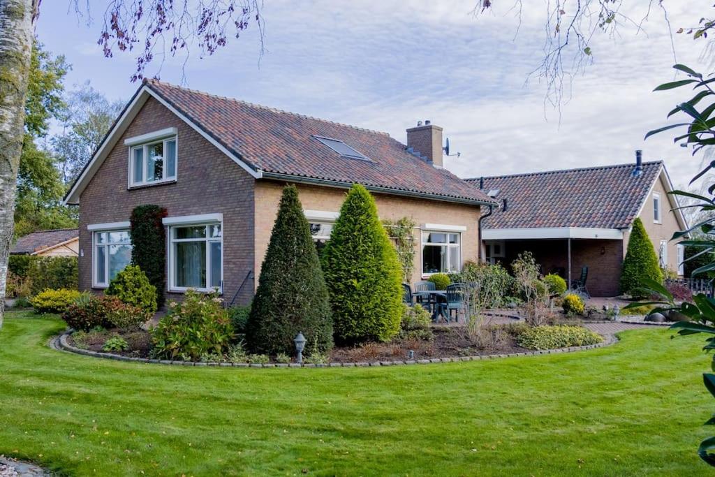 una casa con un prato verde davanti di Vakantiehuis Oostendorp a Meddoo