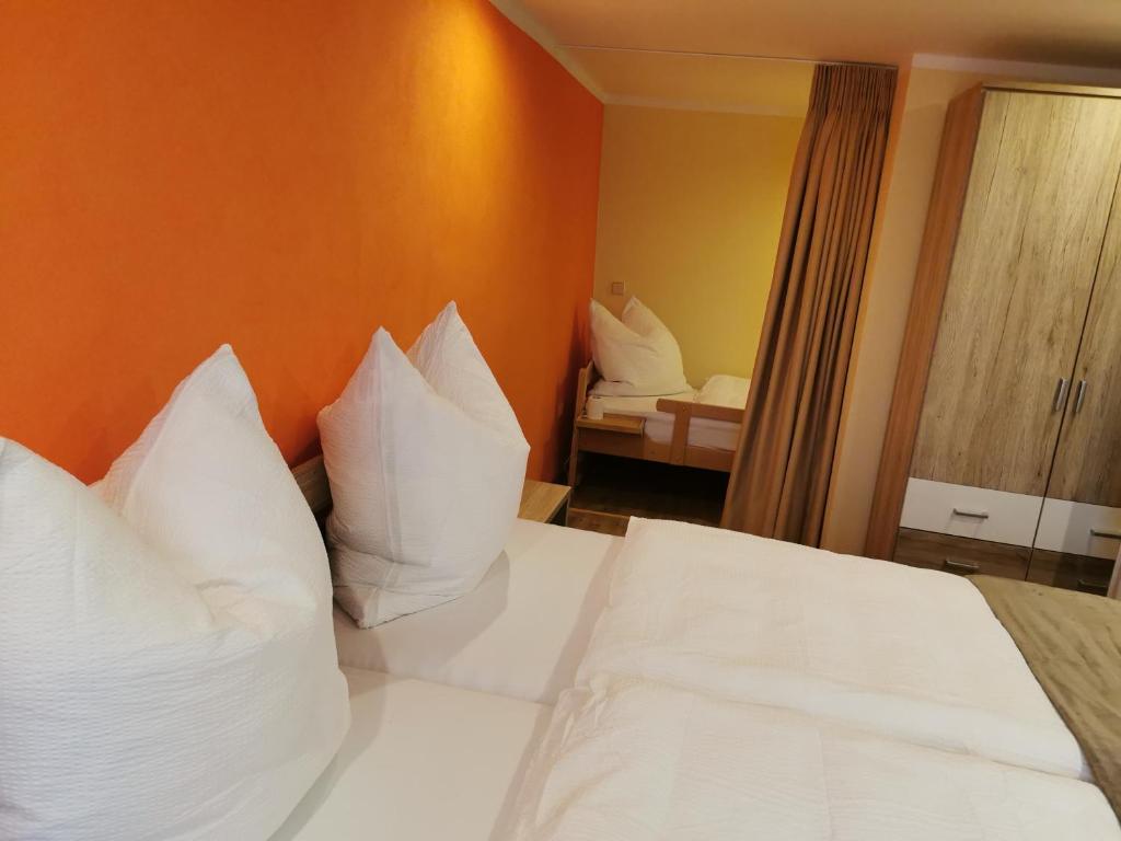 Habitación de hotel con cama con almohadas blancas en Gästewohnung Schönfeld en Frohburg