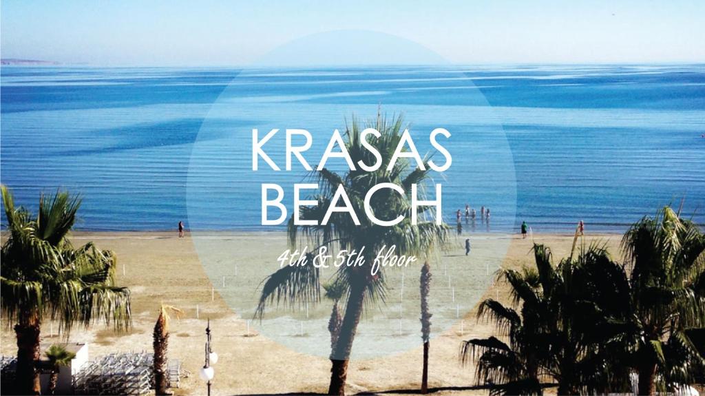 een uitzicht op een strand met palmbomen en de woorden karma strand bij Krasas Beach in Larnaka
