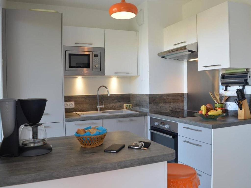 a kitchen with white cabinets and a bowl of fruit on a counter at Appartement Saint-Raphaël, 3 pièces, 4 personnes - FR-1-226A-274 in Saint-Raphaël