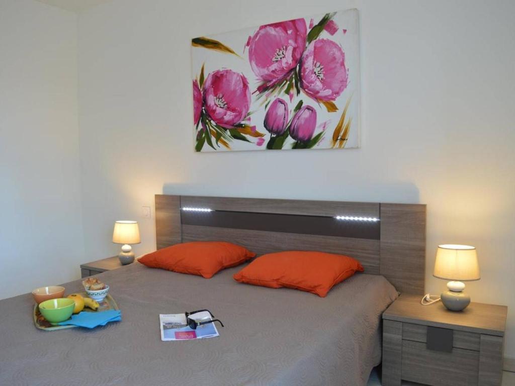 a bedroom with a bed with red pillows and a painting at Appartement Saint-Raphaël, 3 pièces, 4 personnes - FR-1-226A-274 in Saint-Raphaël