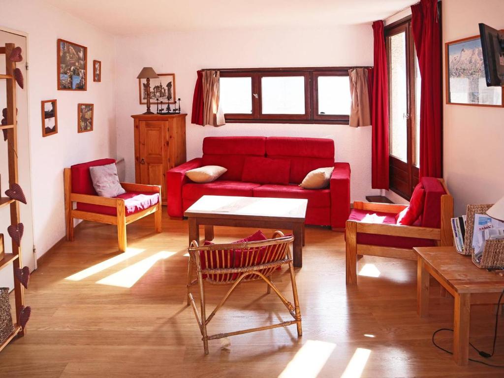 a living room with a red couch and chairs at Appartement Les Orres, 2 pièces, 8 personnes - FR-1-322-191 in Les Orres