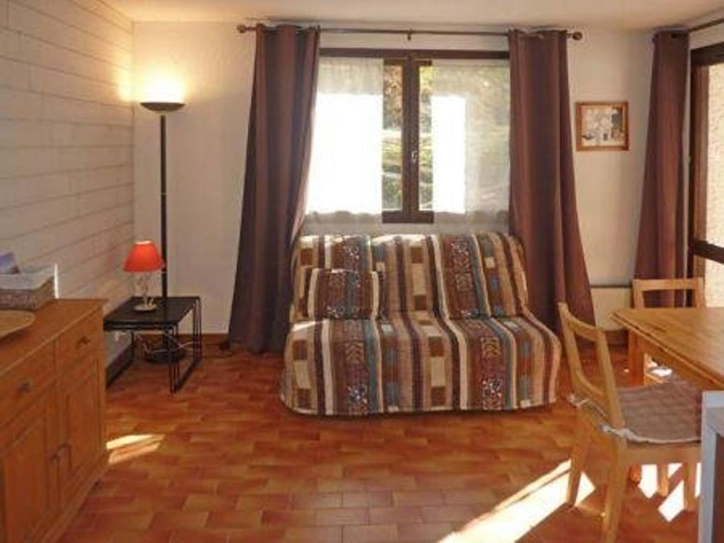 un salon avec un lit et une fenêtre dans l'établissement Studio confortable au centre des Orres, balcon, pour 4 personnes - FR-1-322-215, aux Orres