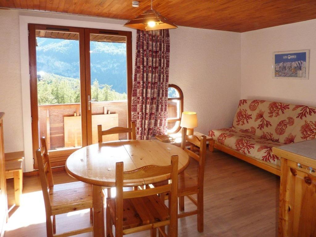 a living room with a table and a couch at Appartement Les Orres, 1 pièce, 4 personnes - FR-1-322-255 in Les Orres