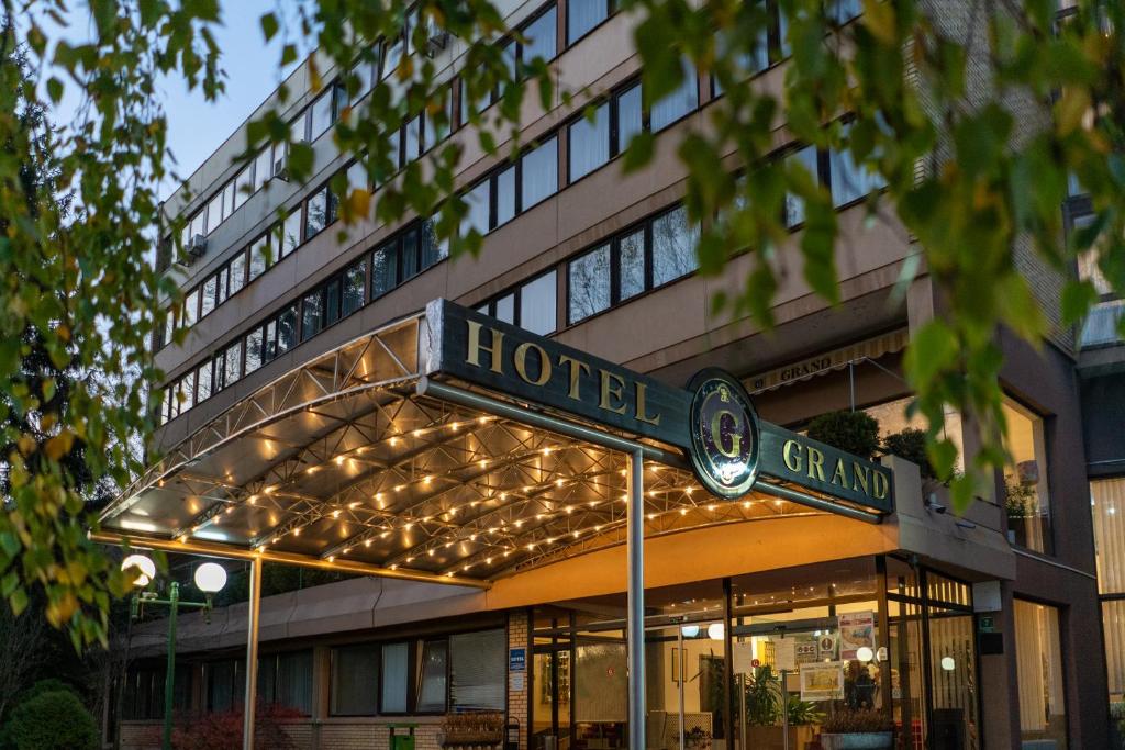 ein Hotel mit einem Schild vor einem Gebäude in der Unterkunft Hotel Grand in Sarajevo