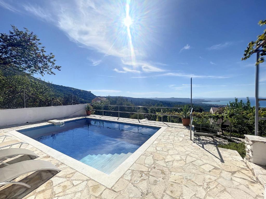 a swimming pool with a view of the ocean at Villa Corfou in Corfu