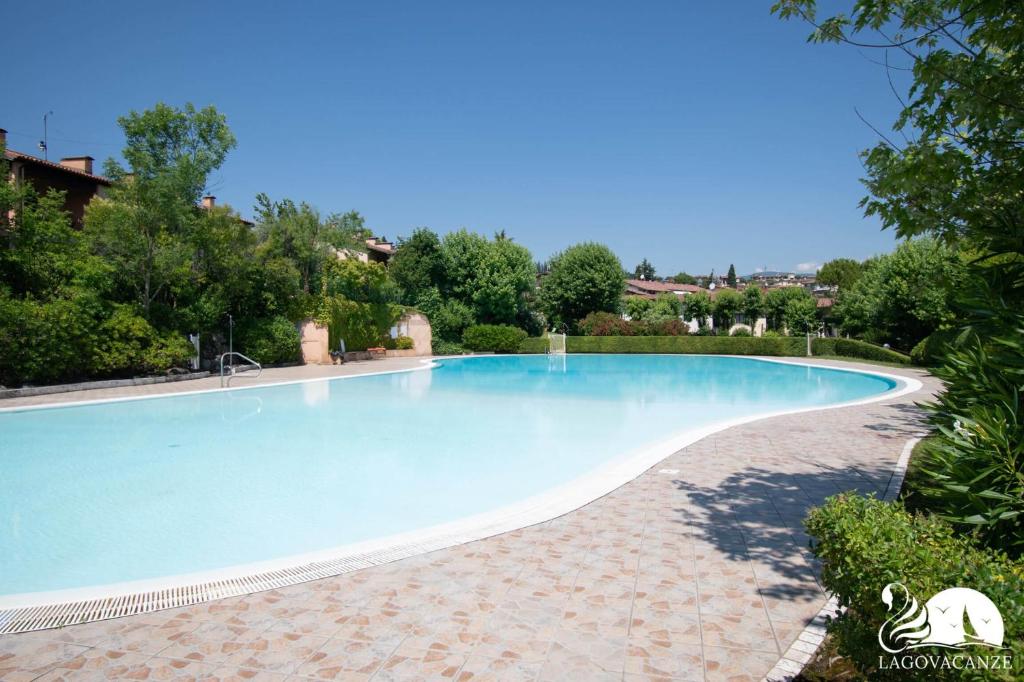 a large swimming pool in a villa with trees at Paraìso del Sol in Polpenazze del Garda