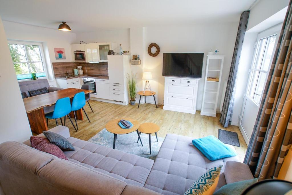 a living room with a couch and a table and a kitchen at Ferienwohnung 11 "Gut Tossens" in Tossenserdeich