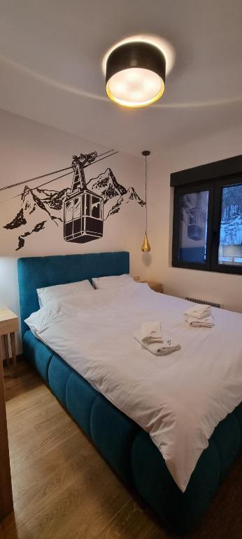 - une chambre dotée d'un grand lit avec une tête de lit bleue dans l'établissement Apartman Sihrovski - Vila Pekovic Blue Zlatibor, à Zlatibor