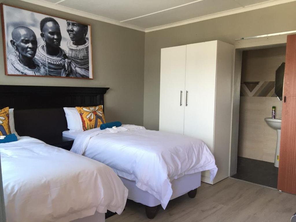 um quarto com 2 camas e um lavatório em Radies Bed and Breakfast em Cofimvaba