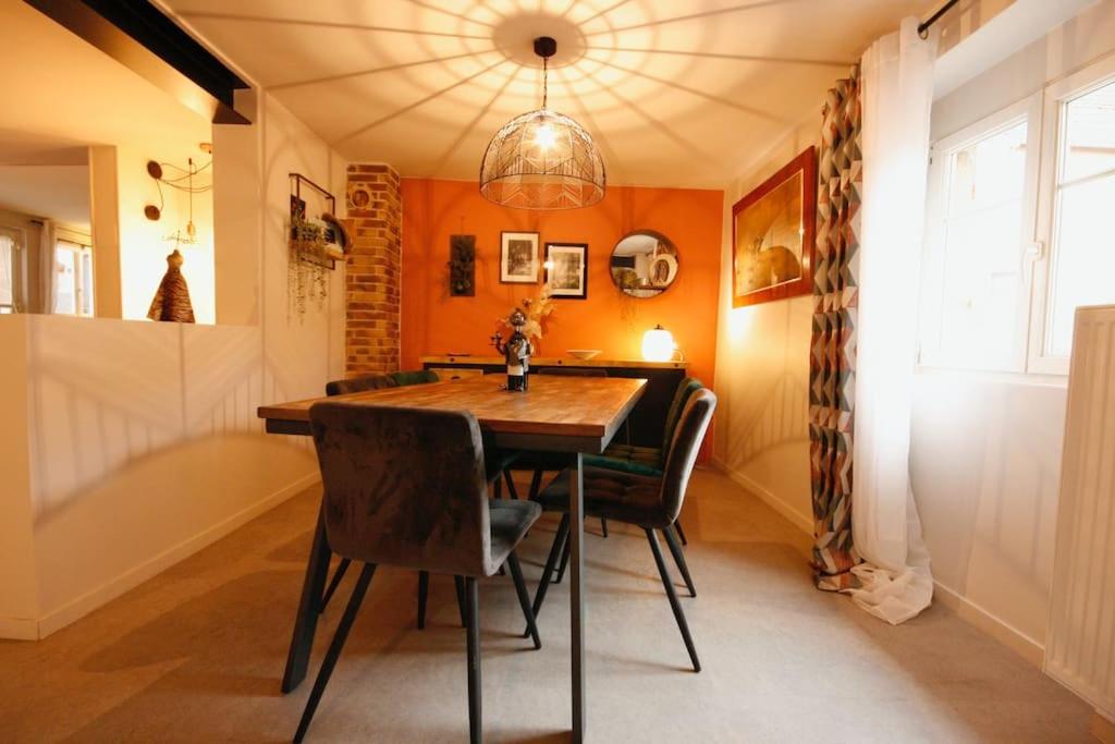 jadalnia z drewnianym stołem i krzesłami w obiekcie Gîte Aux Quatre Vents avec Terrasse w mieście Rouffach