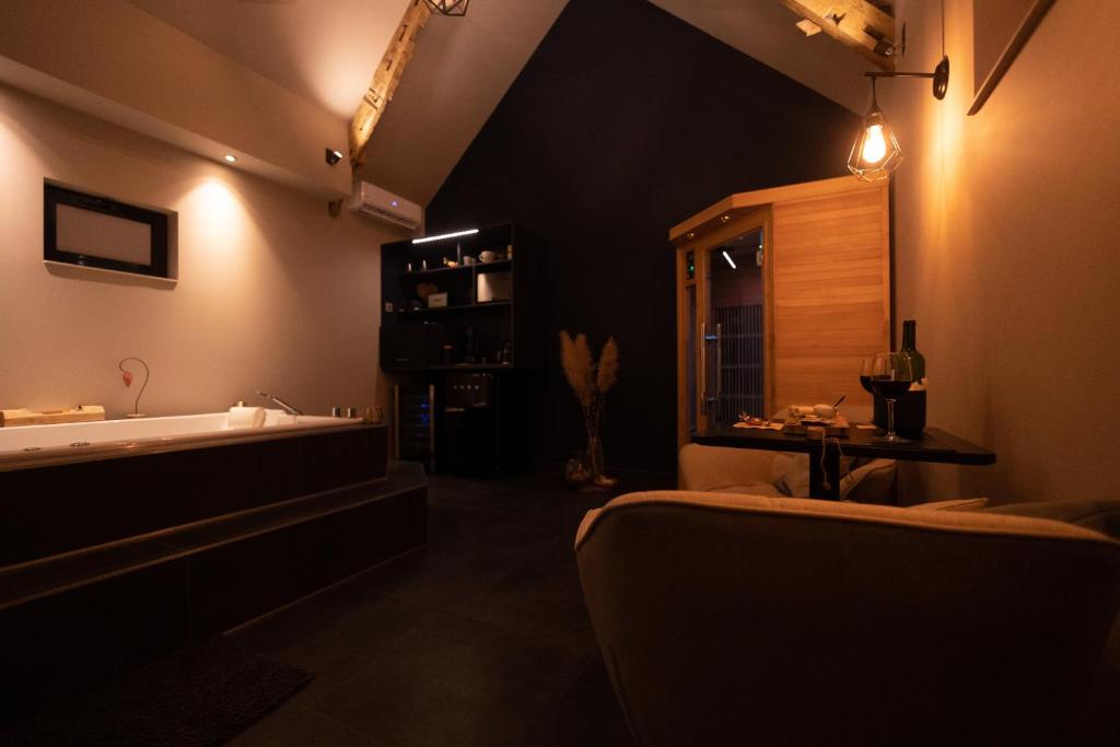 baño grande con bañera y lavamanos en Le Cottage Suite avec Spa Privatif, 