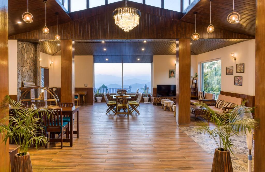 a lobby with tables and chairs and a dining room at The Frostwood Resort in Rānīkhet