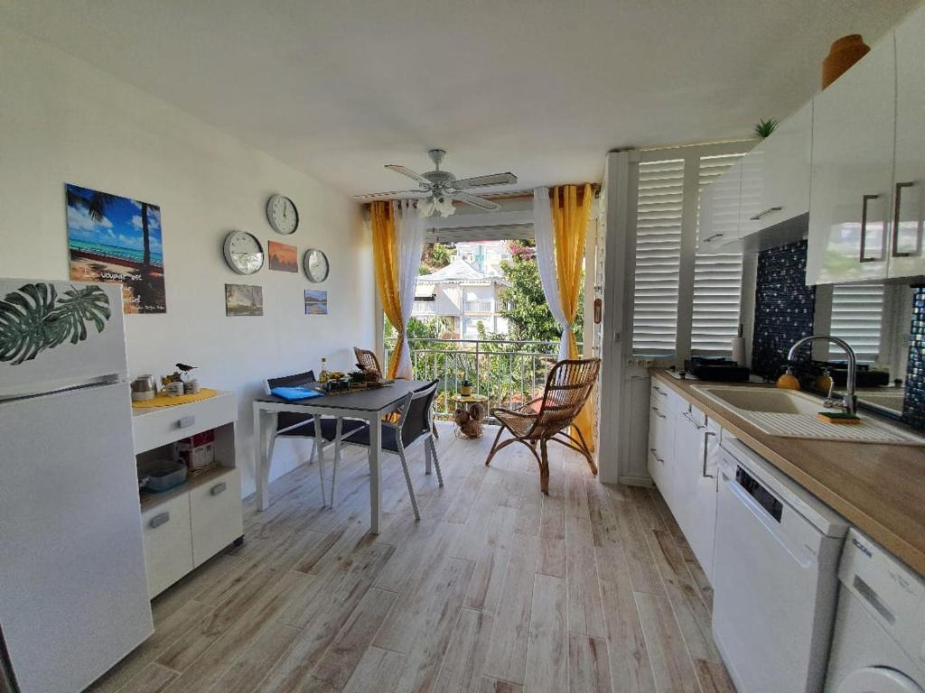 a kitchen with a table and a kitchen with a dining room at Ti Kaz Effet Mer in Saint-François