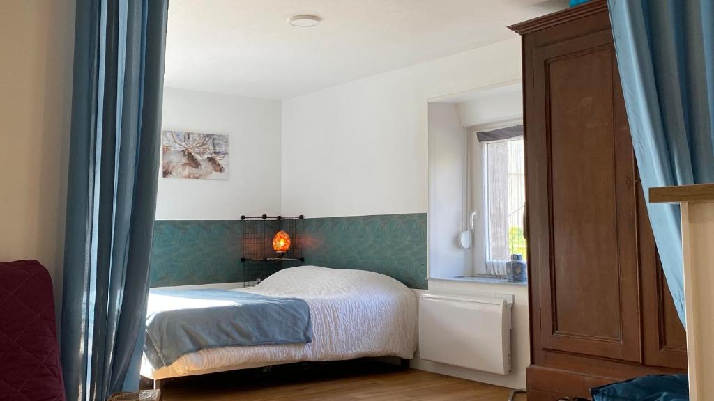 a bedroom with a bed and a window at Gîte du cerisier in Raddon-et-Chapendu