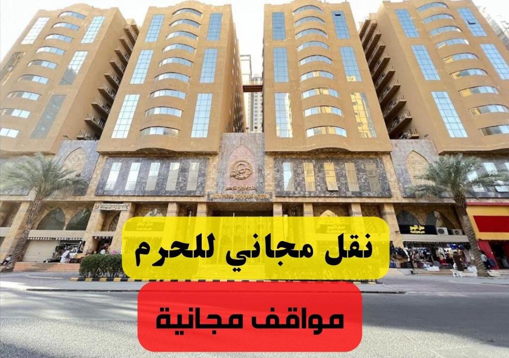 una señal frente a un edificio con edificios en Al Tayseer Towers Tuwa Hotel فندق ابراج التيسير طوى, en La Meca