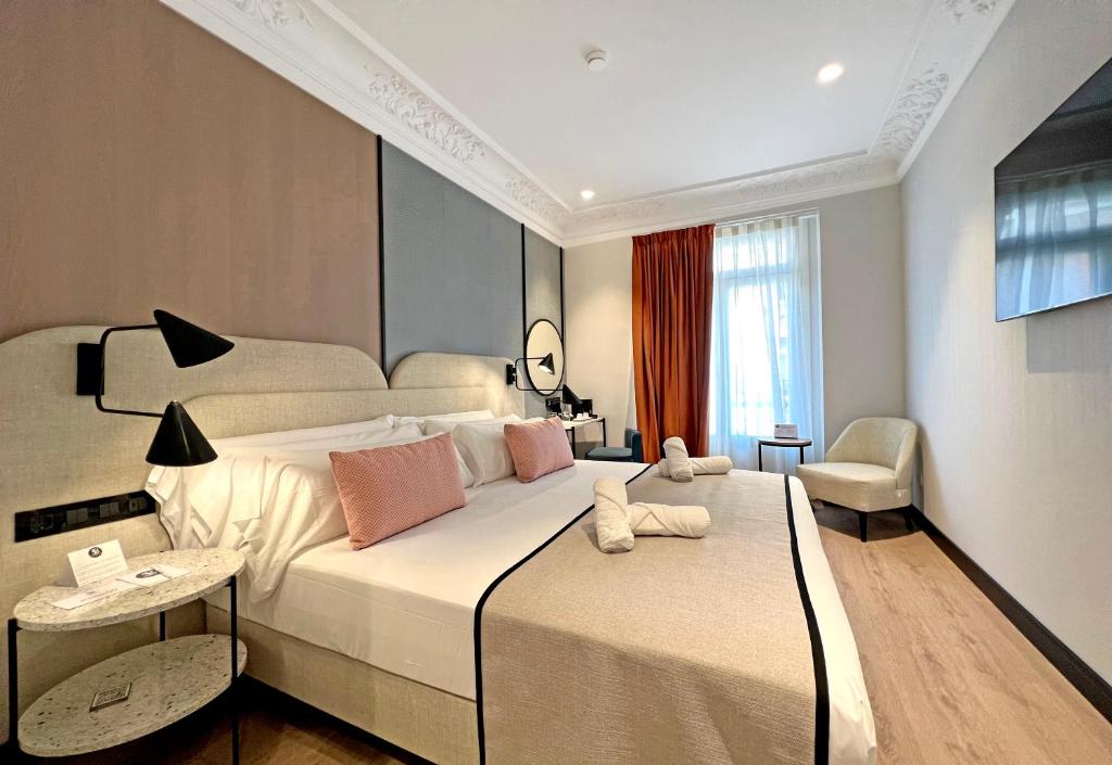 1 dormitorio con 1 cama blanca grande y 1 silla en Soho Boutique Turia, en Valencia
