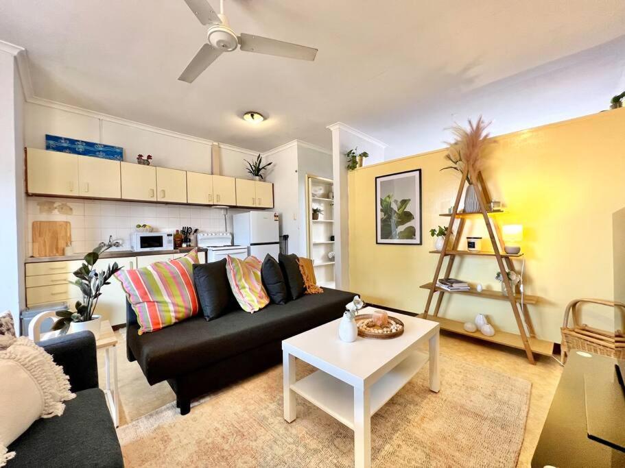 - un salon avec un canapé noir et une table dans l'établissement Cosy unit by the beach, à Port Hedland