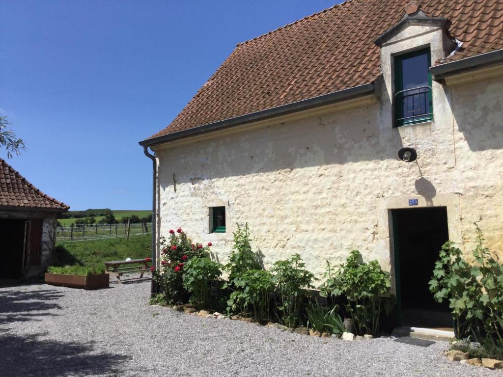 a white brick building with a door and some flowers at Le Big Family - LE MONT DE LA LOUVE in Bazinghen