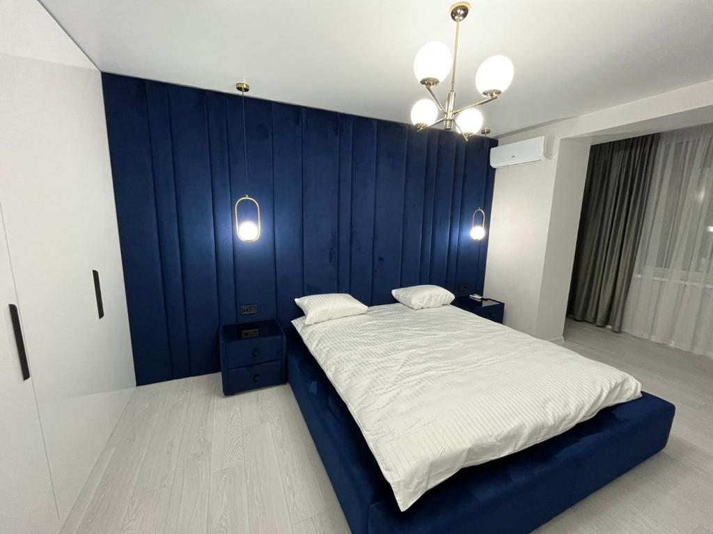 ein Schlafzimmer mit einer blauen Wand und einem Bett in der Unterkunft Апартаменти Люкс3 зі світлом in Chmelnyzkyj