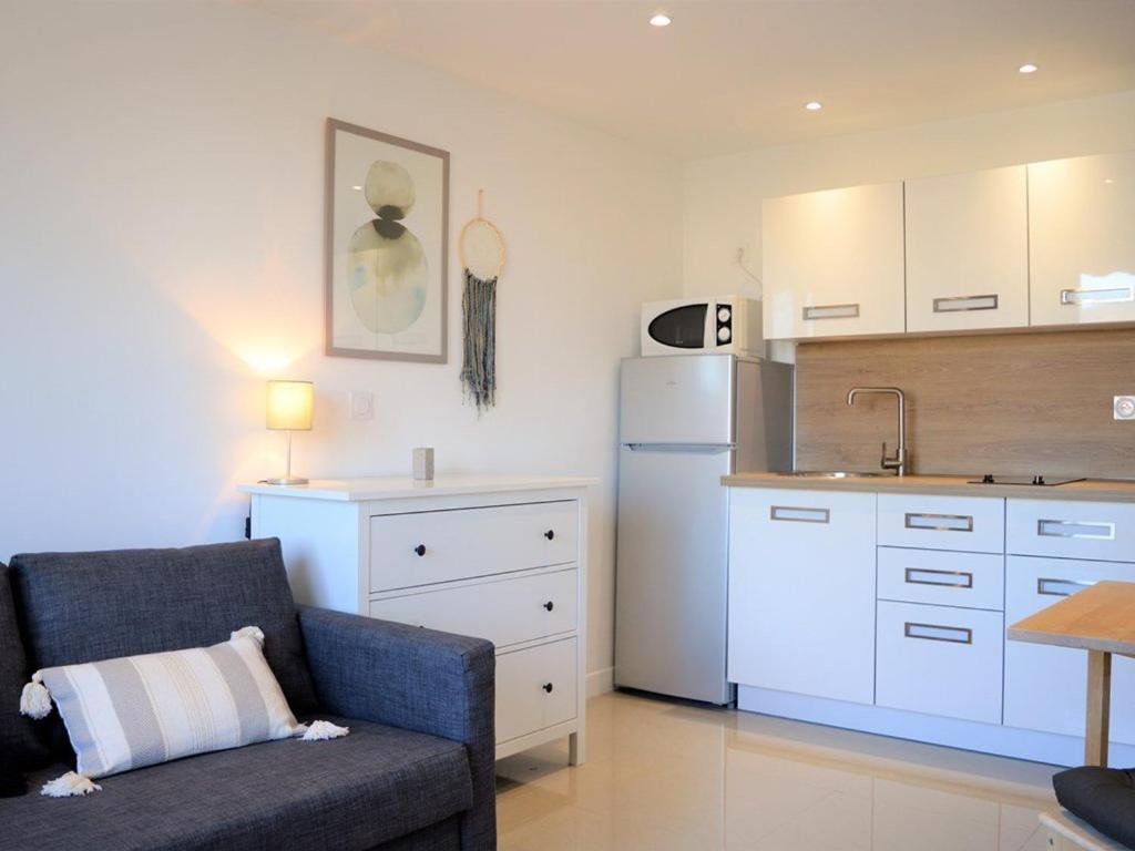 un salon avec un canapé et une cuisine dans l'établissement Studio 2 pers au Lavandou, près plage, parking, ménage inclus - FR-1-251-78, au Lavandou