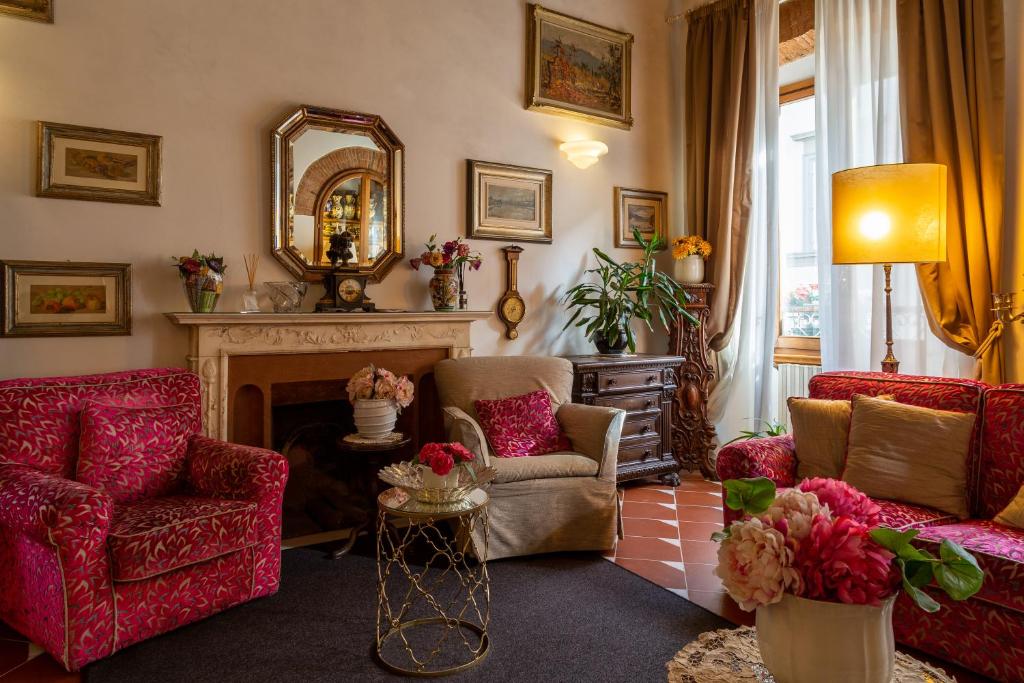 a living room with two chairs and a fireplace at Hotel Maxim Axial in Florence