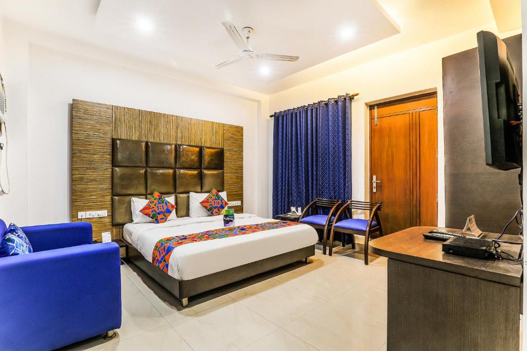 a hotel room with a bed and a couch and a television at FabHotel The Residency DLF Galleria in Gurgaon