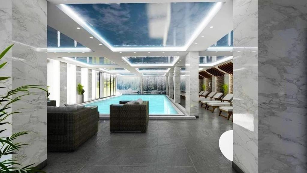 a swimming pool with a couch and chairs in a building at President KOP A515 in Kopaonik