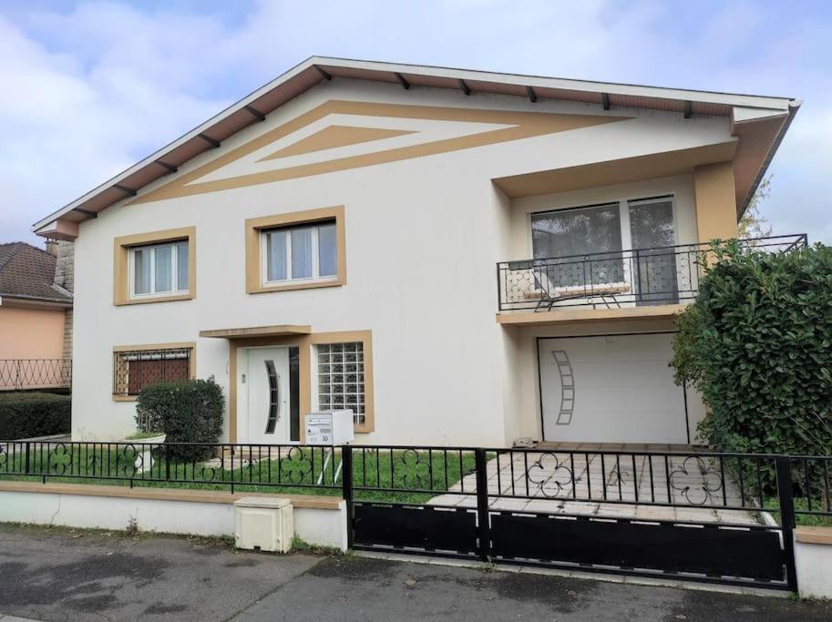 a white house with a black fence in front of it at Villa Sainte-Rose 3ch à 5 minutes de la Cité des Loisirs in Amnéville