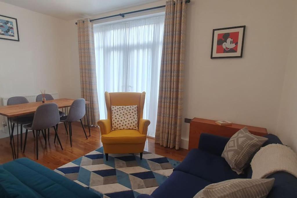a living room with a couch and a table and chairs at Charming flat near Shoreditch in London