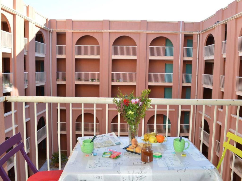 une table avec un vase de fleurs sur un balcon dans l'établissement Studio calme et central à Saint Aygulf, plage à 300m, marché provençal à pied, 3 couchages. - FR-1-226A-107, à Saint-Aygulf