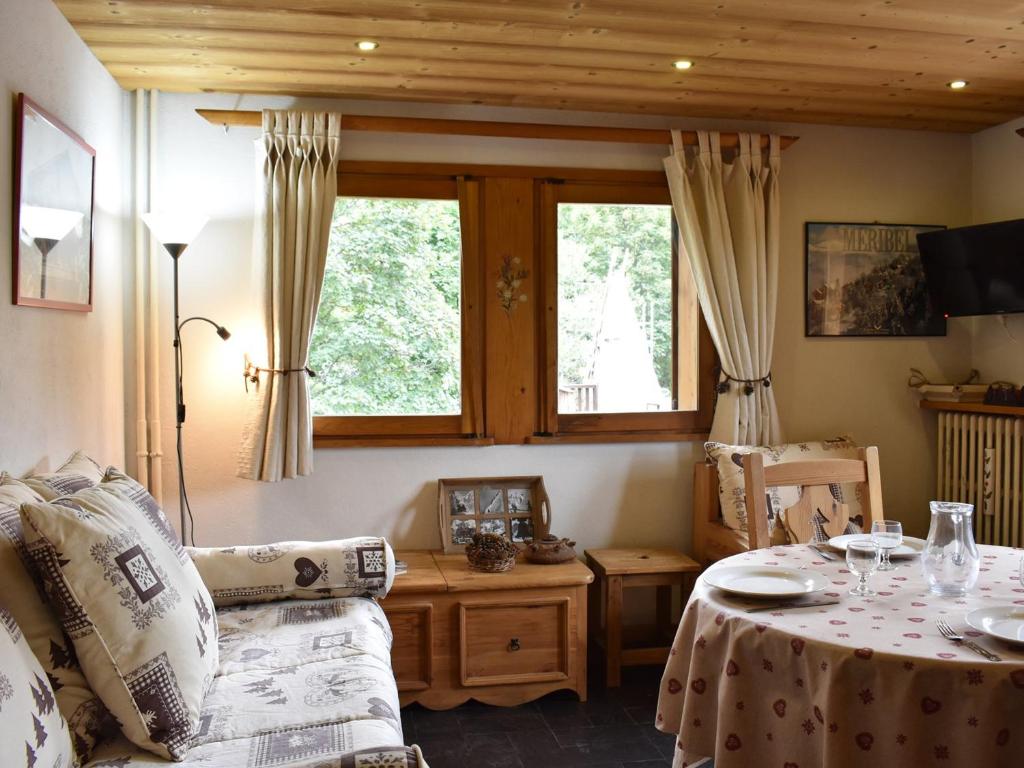 ein Wohnzimmer mit einem Sofa und einem Tisch in der Unterkunft Appartement Méribel, 2 pièces, 4 personnes - FR-1-180-207 in Méribel