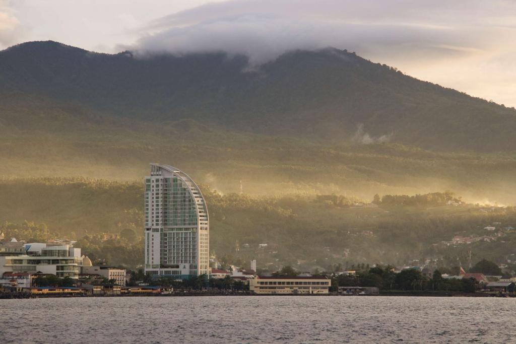 a tall building in front of a mountain at Best Western The Lagoon Hotel in Manado