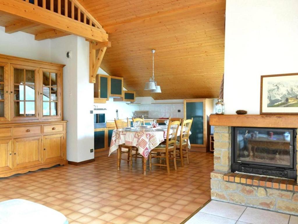 a kitchen and dining room with a table and a fireplace at Appartement Le Grand-Bornand, 3 pièces, 7 personnes - FR-1-241-50 in Le Grand-Bornand