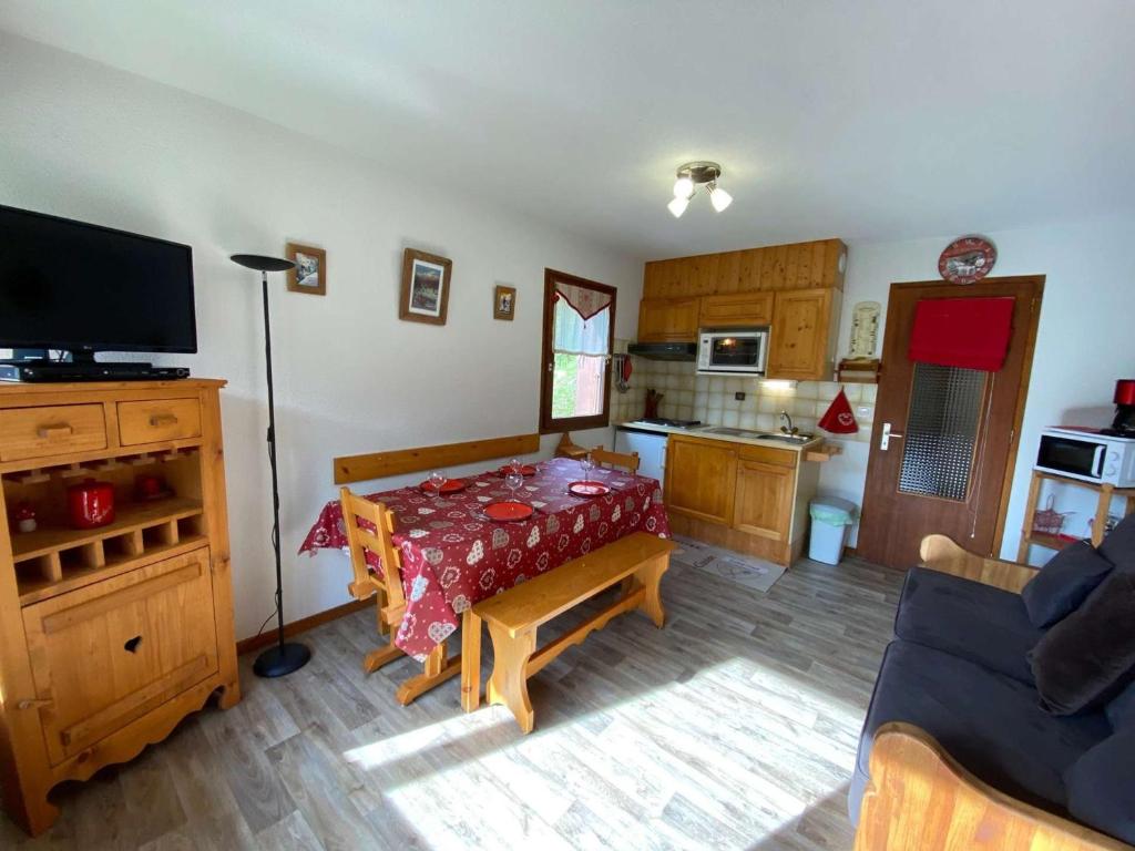a living room with a couch and a tv and a kitchen at Appartement Le Grand-Bornand, 2 pièces, 6 personnes - FR-1-241-52 in Le Grand-Bornand