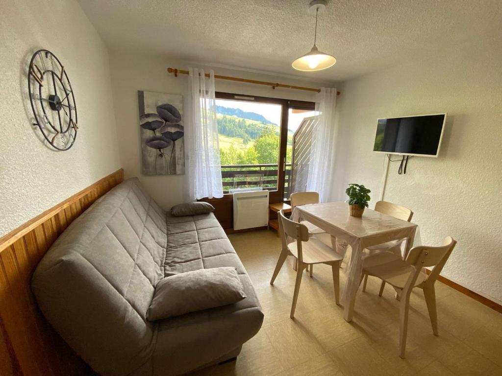 ein Wohnzimmer mit einem Sofa und einem Tisch in der Unterkunft Studio Le Grand-Bornand, 1 pièce, 4 personnes - FR-1-241-19 in Le Grand-Bornand