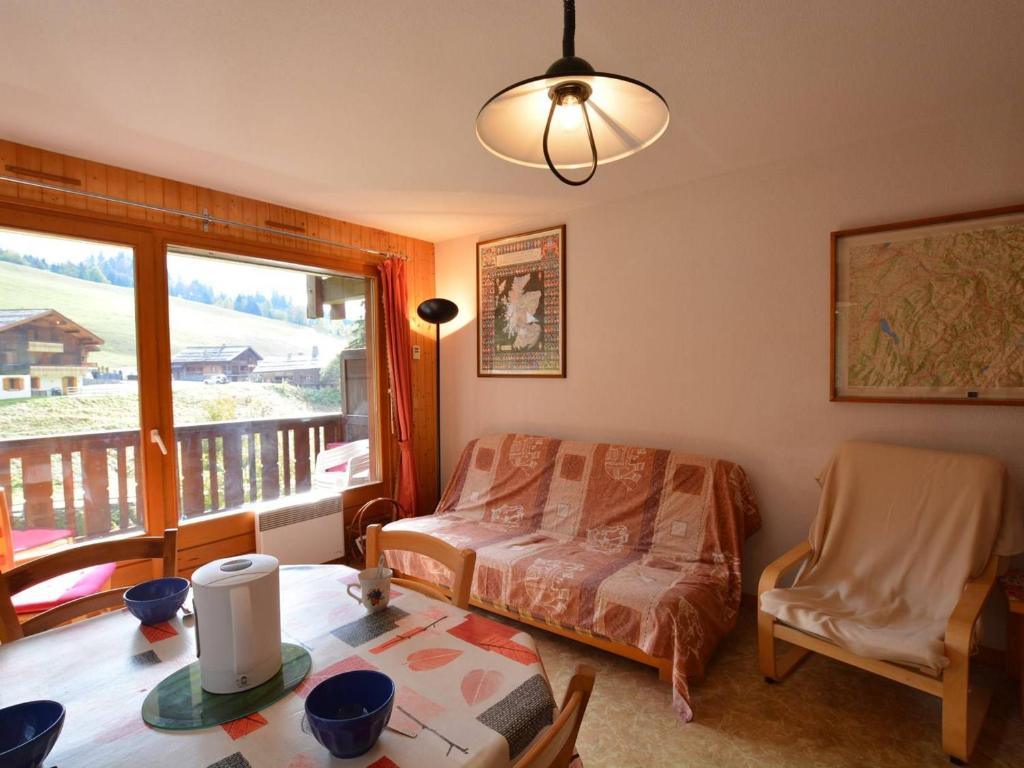 a living room with a table and a bed and a window at Appartement Le Grand-Bornand, 2 pièces, 6 personnes - FR-1-241-17 in Le Grand-Bornand