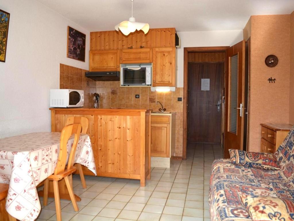 大博爾南的住宿－Appartement Le Grand-Bornand, 1 pièce, 4 personnes - FR-1-241-51，厨房以及带桌子和沙发的用餐室。