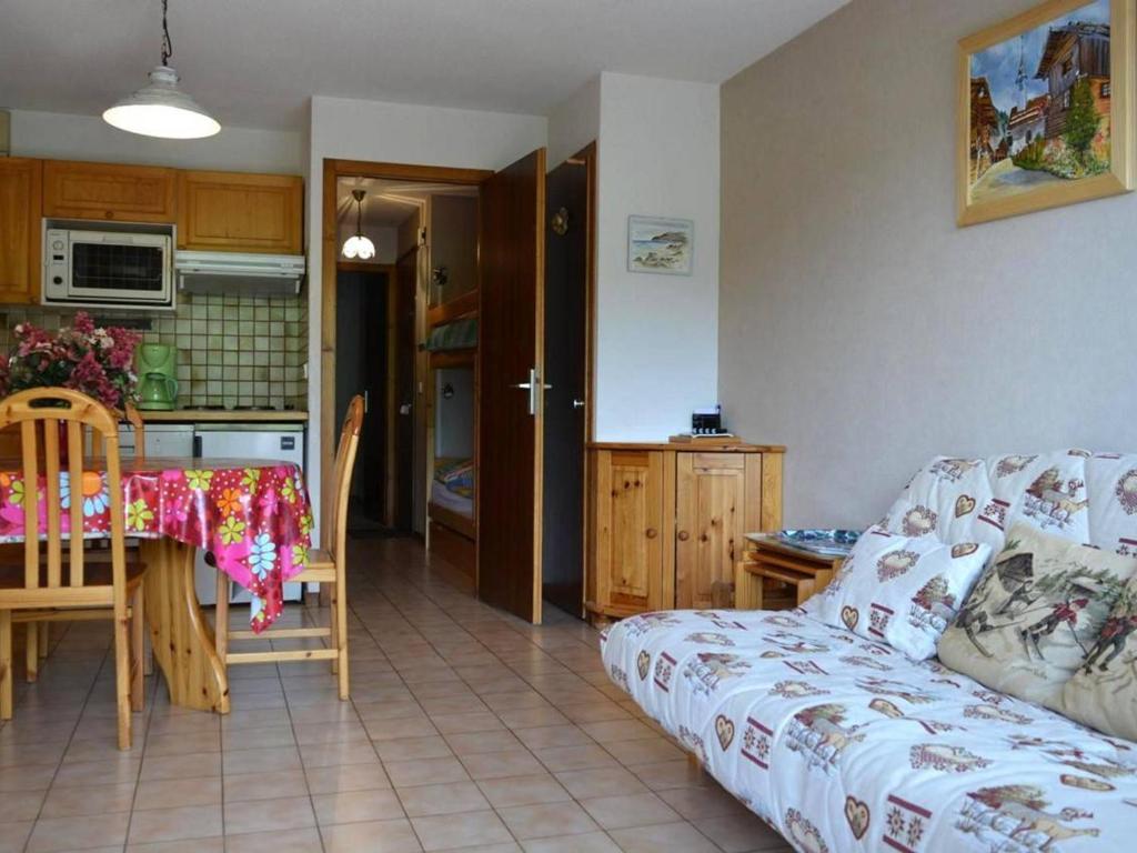 un salon avec un canapé et une table et une cuisine dans l'établissement Appart. cosy 2 pièces, 6 pers, terrasse, garage, proche pistes - Le Grand-Bornand - FR-1-241-25, au Grand-Bornand