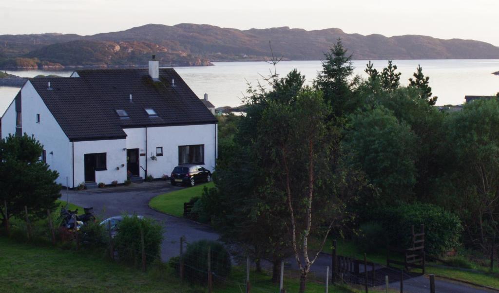 ein weißes Haus mit Blick auf das Wasser in der Unterkunft Davar in Lochinver