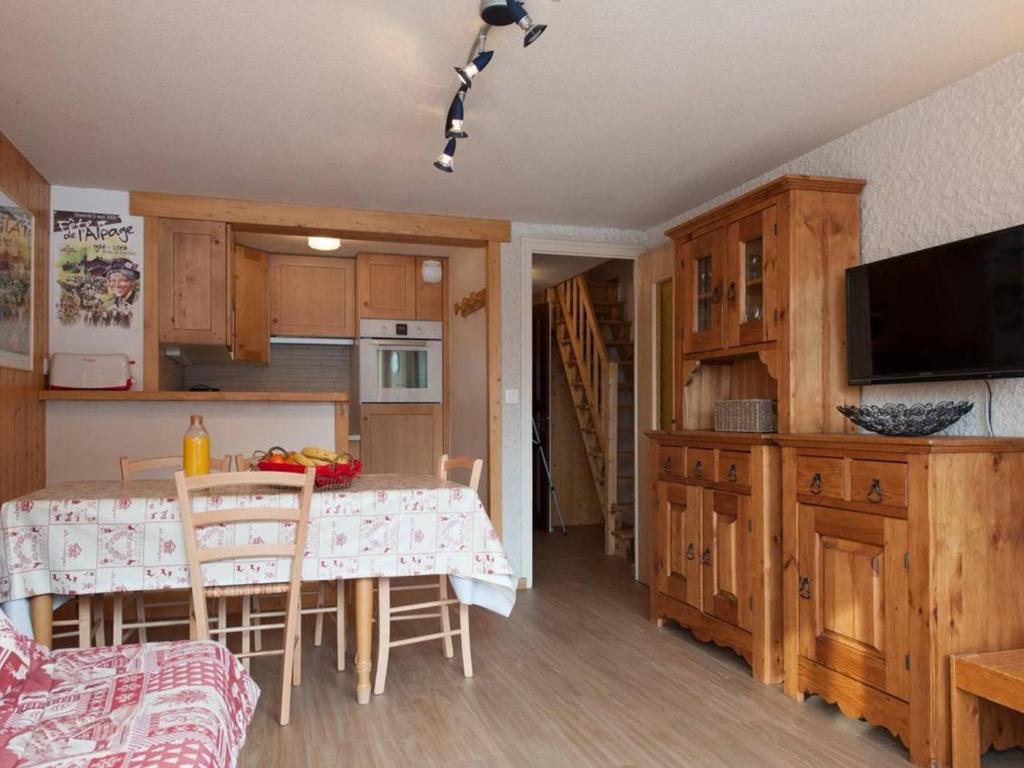 a kitchen with a table and chairs and a kitchen with wooden cabinets at Appartement Le Grand-Bornand, 3 pièces, 6 personnes - FR-1-241-117 in Le Grand-Bornand