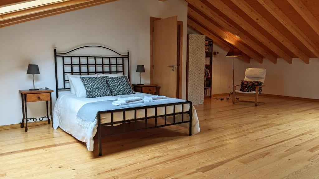 een slaapkamer met een groot bed en een houten vloer bij Casa Domingues Guest House in Caldas da Rainha