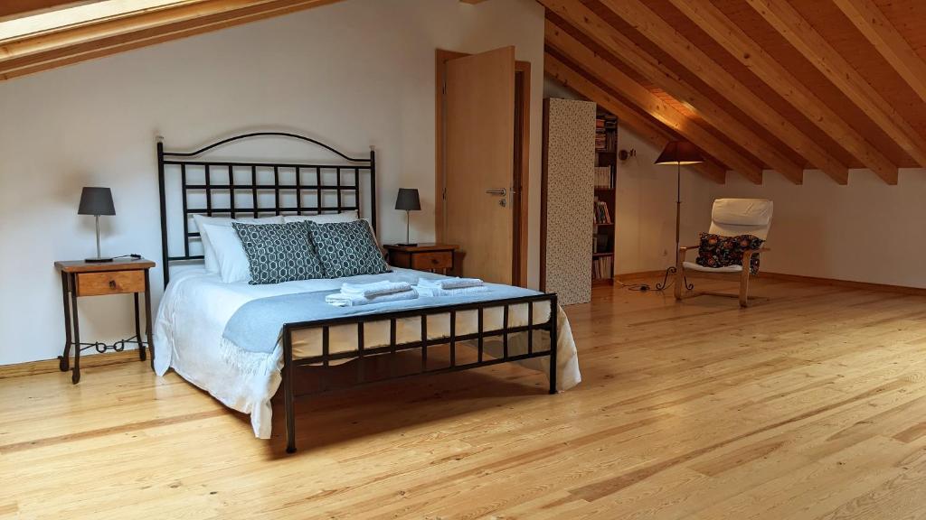 - une chambre avec un grand lit et du parquet dans l'établissement Casa Domingues Guest House, à Caldas da Rainha
