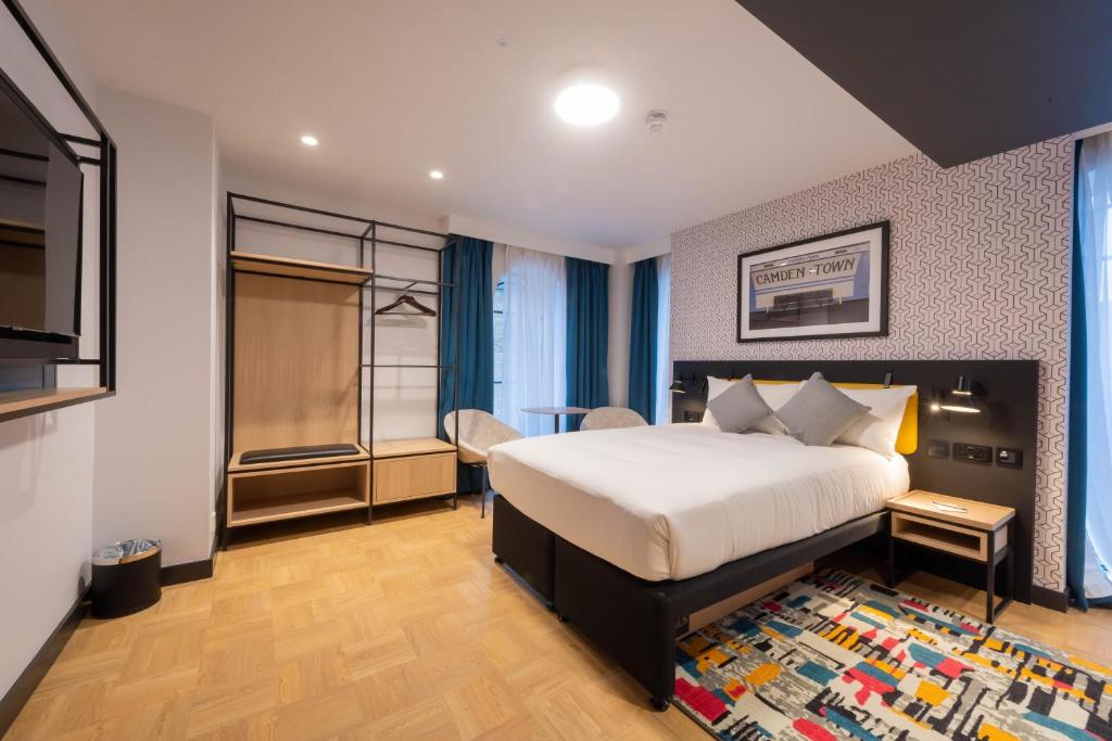 a hotel room with a bed and a television at The Wesley Camden Town in London