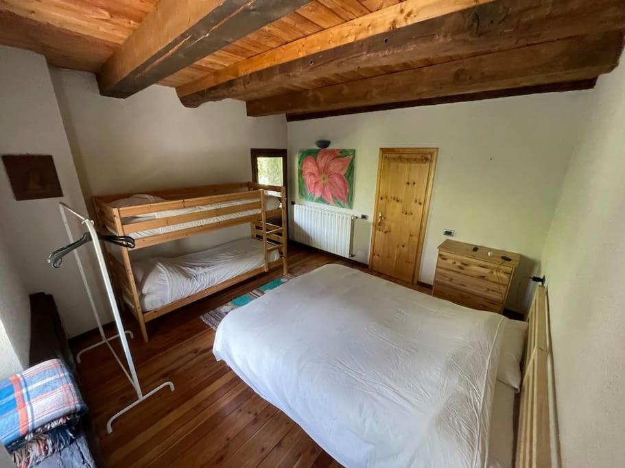 1 dormitorio con 2 camas y techo de madera en Chalet Baita Magugnaga, en Ceppo Morelli