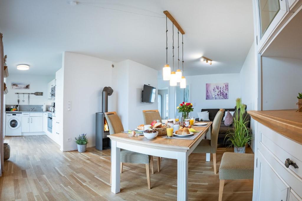 a kitchen and dining room with a table and chairs at Fewo MEERwert by Seeblick Ferien ORO, Familienfreundlich, Sauna, Kamin,XL Dusche in Olpenitz