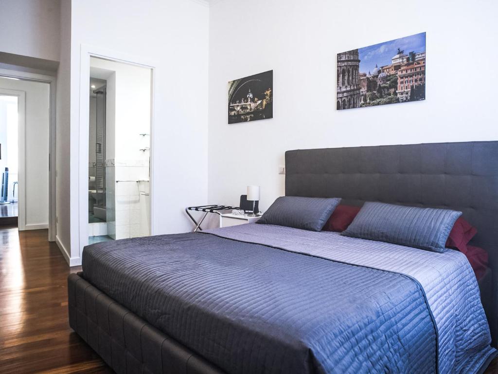 a bedroom with a large bed with a blue blanket at Saint Peter House Station in Rome