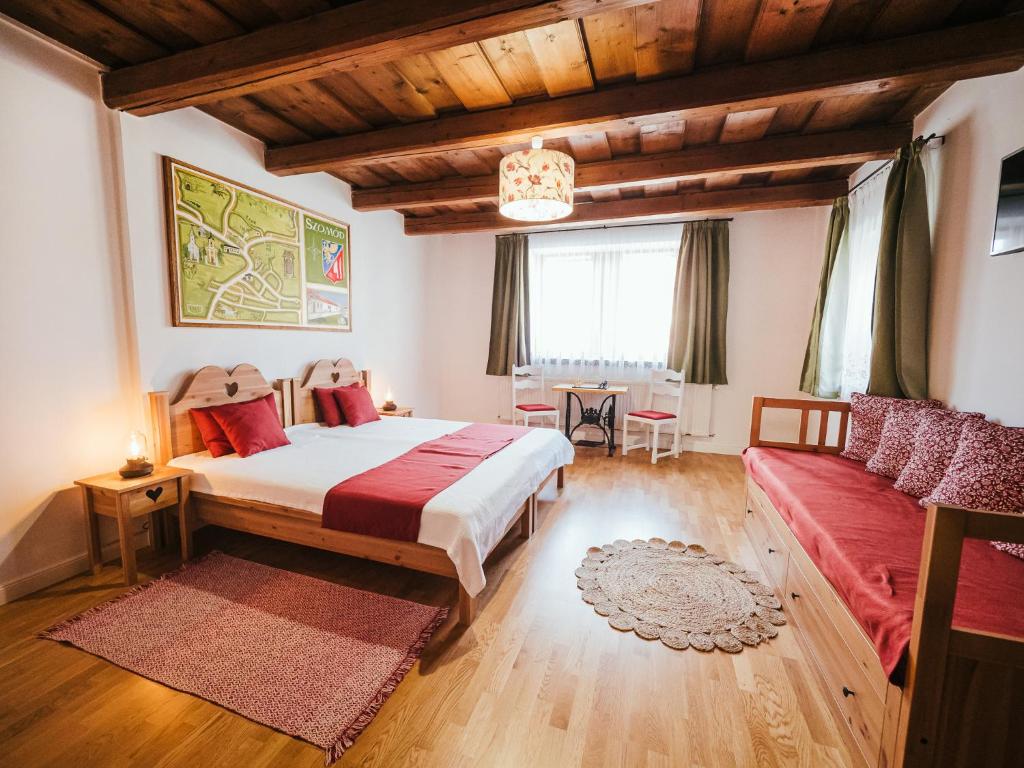 a bedroom with a large bed and a couch at A MI KISHÁZUNK vendégház in Szomód