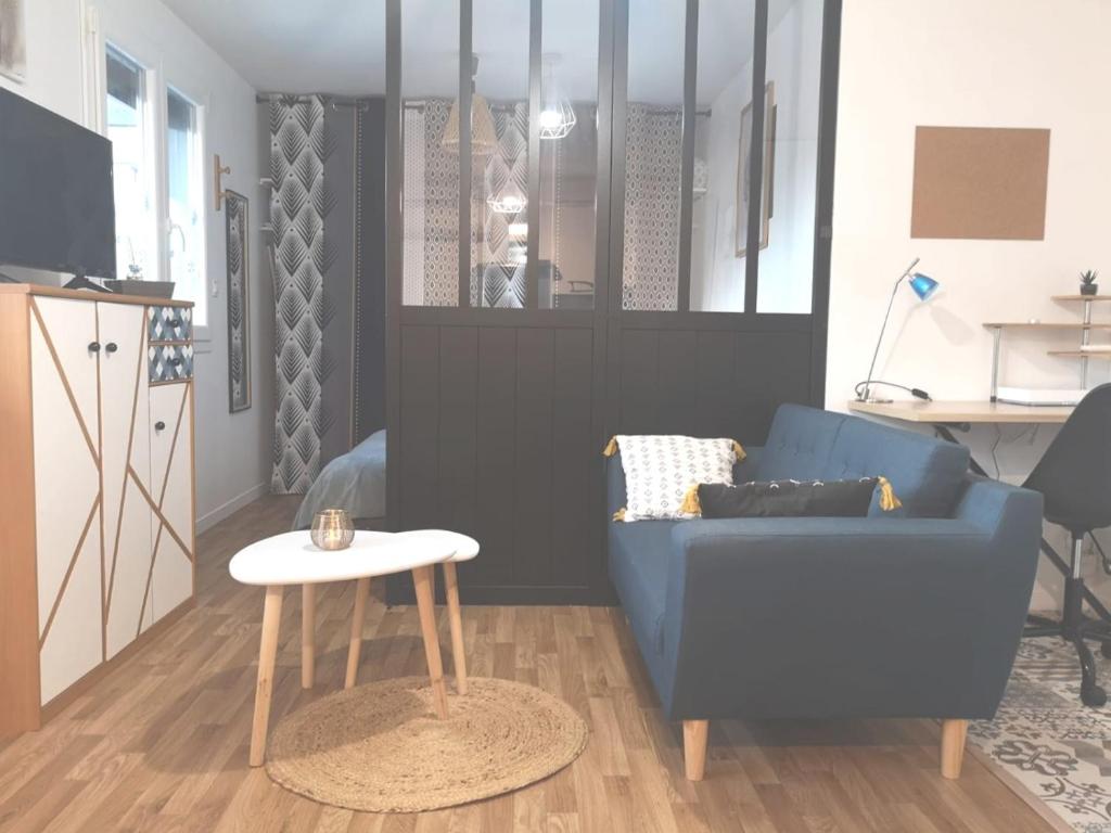 sala de estar con sofá azul y mesa en Cosy flat proche Gare & Parking - clim, en Agen