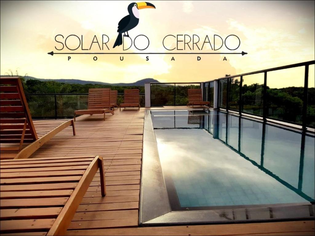 a resort deck with a pool and a sign that says solar do carrot at Pousada solar do Cerrado in Rifaina